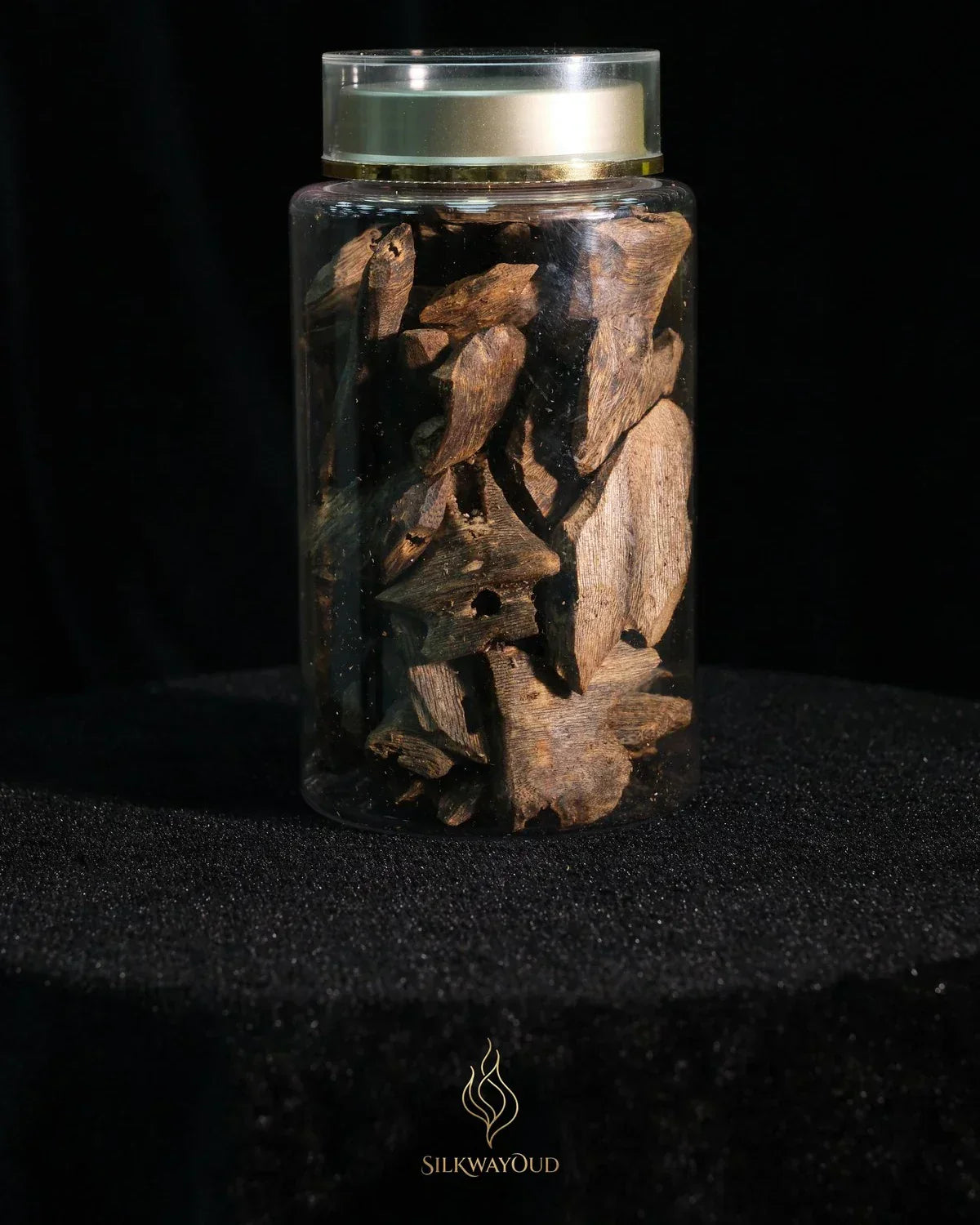 High-grade agarwood chips showing dark resin streaking through pale Aquilaria wood grain